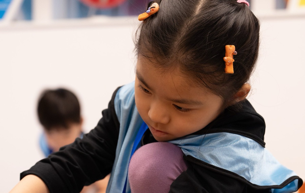Young student building her first machine at a JBC event