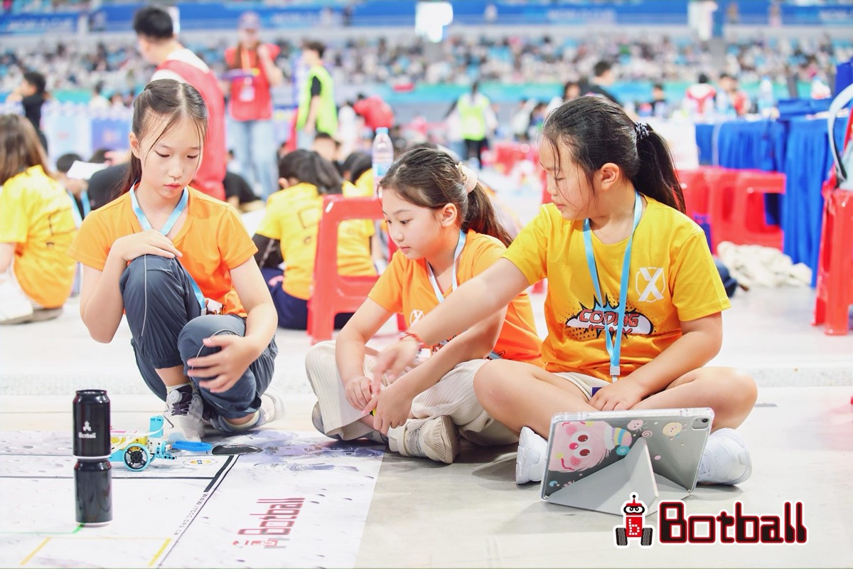 Primary students programming their robot on the JBC game field